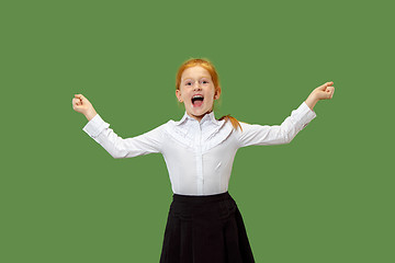 Image showing The happy teen girl standing and smiling against green background.