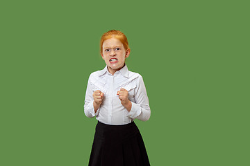 Image showing Portrait of angry teen girl on a green studio background