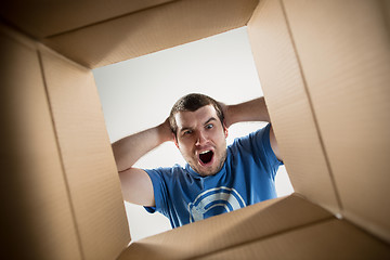 Image showing Man unpacking and opening carton box and looking inside