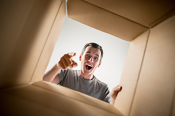 Image showing Man unpacking and opening carton box and looking inside