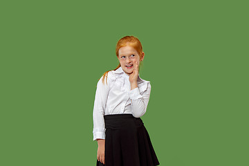 Image showing The young teen girl whispering a secret behind her hand over green background