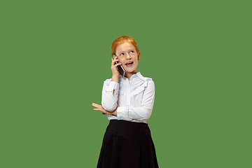 Image showing The happy teen girl standing and smiling against green background.