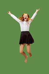 Image showing Young happy caucasian teen girl jumping in the air , isolated on green background