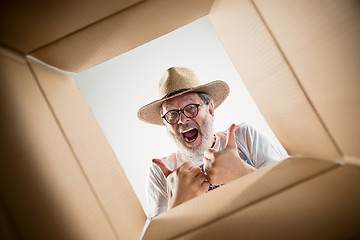 Image showing Man unpacking and opening carton box and looking inside