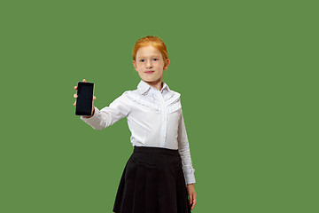 Image showing The happy teen girl standing and smiling against green background.