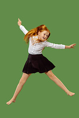 Image showing Young happy caucasian teen girl jumping in the air , isolated on green background