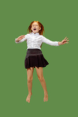 Image showing Young happy caucasian teen girl jumping in the air , isolated on green background