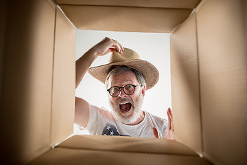 Image showing Man unpacking and opening carton box and looking inside