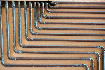Image showing some copper tubes outside on a wall