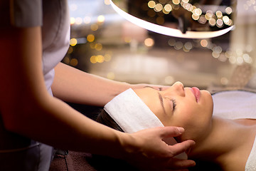 Image showing beautician doing face massage to woman at spa