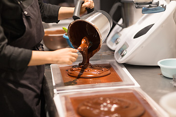 Image showing confectioner makes chocolate dessert at sweet-shop