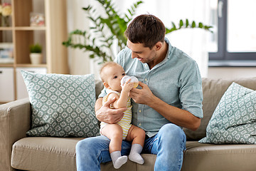 Image showing father and baby drinking from bottle at home