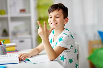 Image showing boy doing homework and counting using fingers