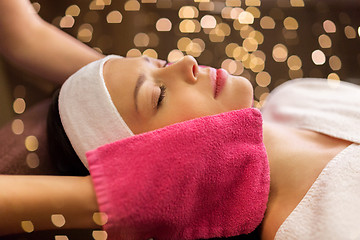 Image showing woman having face massage with terry gloves at spa