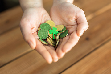 Image showing hands with golden coins and shamrock leaf