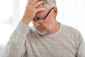 Image showing senior man suffering from headache at home