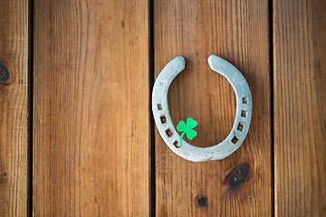 Image showing horseshoe with shamrock on wooden background