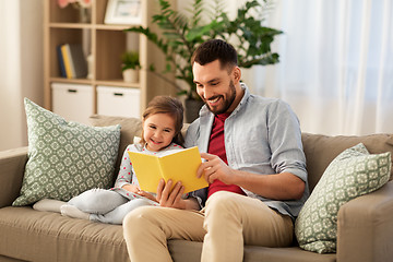 Image showing happy father and daughter reading book at home