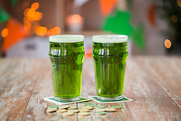 Image showing glasses of green beer and gold coins on table