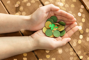 Image showing hands with golden coins and shamrock leaf