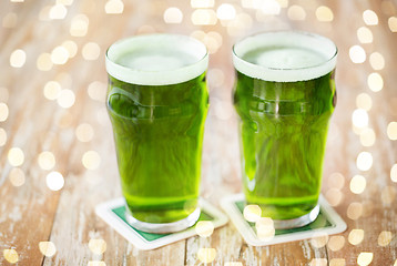 Image showing two glasses of green beer on wooden table