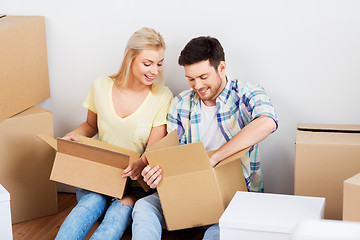 Image showing happy couple unpacking boxes at new home