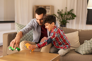 Image showing father and son playing with toy cars at home