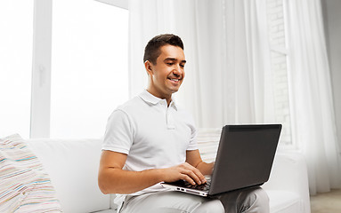 Image showing happy man with laptop computer at home