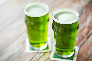 Image showing two glasses of green beer on wooden table