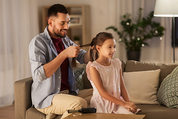 Image showing father braiding daughter hair at home