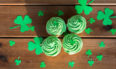 Image showing green cupcakes and shamrock on wooden table