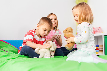 Image showing happy children playing with soft toys at home