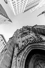 Image showing Wide angle upward view of Trinity Church at Broadway and Wall Street with surrounding skyscrapers, Lower Manhattan, New York City, USA