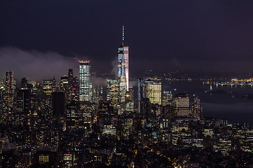 Image showing New York City skyline with lower Manhattan skyscrapers in storm at night.