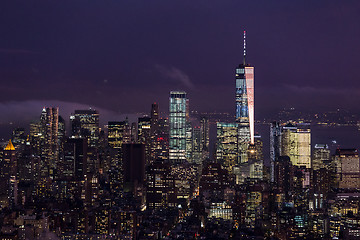 Image showing New York City skyline with lower Manhattan skyscrapers in storm at night.