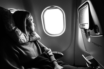 Image showing Tired blonde casual caucasian lady sleepin on seat while traveling by airplane. Commercial transportation by planes.