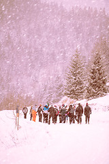 Image showing group of young people walking through beautiful winter landscape