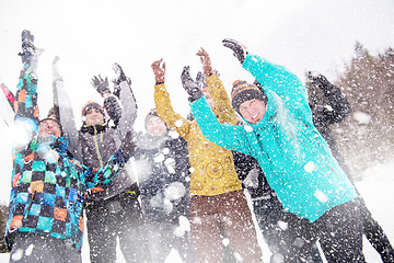 Image showing group of young people throwing snow in the air