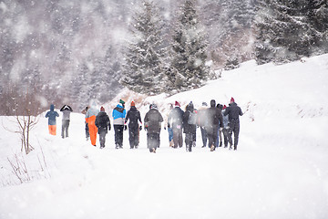 Image showing group of young people walking through beautiful winter landscape