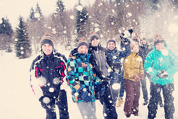 Image showing group of young people throwing snow in the air