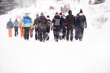 Image showing group of young people walking through beautiful winter landscape