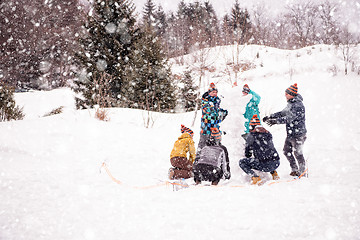 Image showing group of young people making a snowman