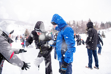 Image showing group of young people making a snowman