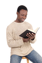 Image showing African man sitting and reading his book