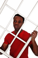 Image showing Surprised African man holding up a window frame