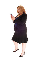 Image showing Big business woman texting on her cell phone