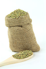 Image showing Fennel seeds in burlap bag and over wooden spoon. 