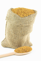 Image showing Fenugreek seeds in burlap bag and over wooden spoon. 