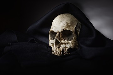 Image showing Closeup photo an old skull covered in black robe