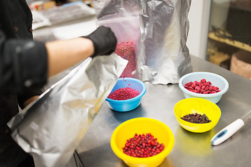 Image showing cook pouring berries into bowl at kitchen